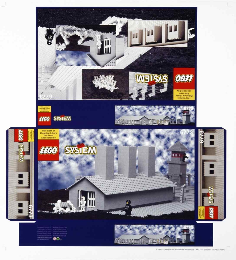 Na płasko rozłożone pudełko od klocków LEGO – na nim widnieje zdjęcie baraku z obozu koncentracyjnego zbudowanego z szarych klocków. Przed barakiem widać ludziki LEGO – strażnik i zmarli więźniowie.