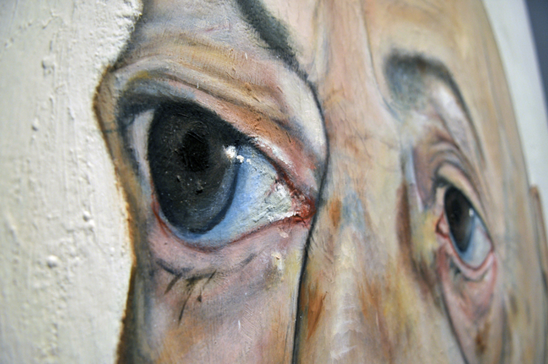 Zdjęcie obrazu przedstawiające głowę starszego, pomarszczonego człowieka z ziemistą cerą i plamami starczymi. Na widocznym fragmencie zbliżenie jest na duże, wyłupiaste oczy