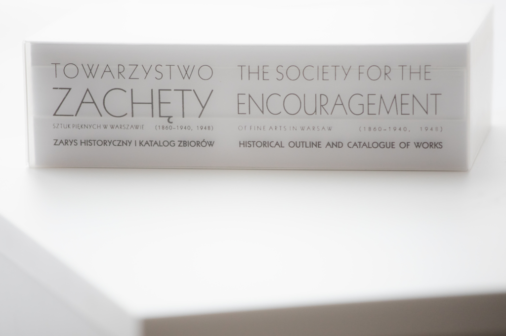 6061a84101412 zdjęcie: grzbiet trzy tomowego wydawnictwa o Towarzystwie Zachęty Sztuk Pięknych - biły grzbiet z czarnym liternictwem. Napis po polsku i angielsku: Towarzystwo Zachęty Sztuk Pięknych. Zarys historyczny i katalog zbiorów