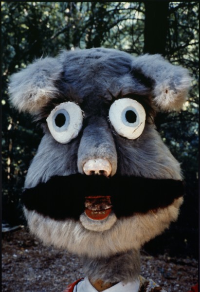 ALT: na zdjęciu duża głowa-maska podobna do Misia Fuzzy wypełniająca prawie cały kadr. W tle drzewa i leśne poszycie