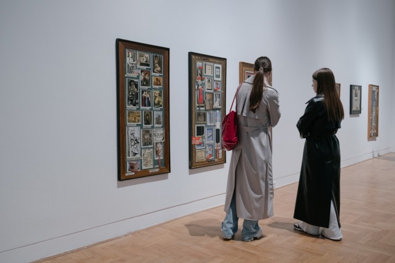 Dwie osoby oglądające obraz na wystawie.