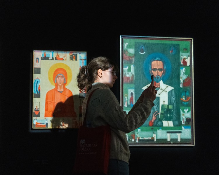 Zdjęcie; kadr przedstawiający zwiedzającą oraz ikony na wystawie Jerzy Nowosielski.
