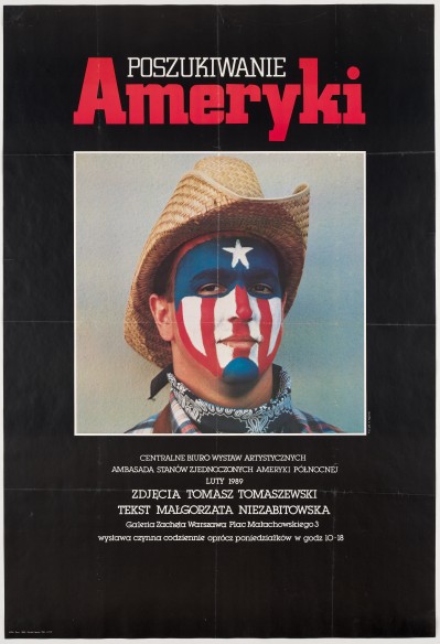 Czarne tło. Na środku kwadratowe zdjęcie mężczyzny w kapeluszu kowbojskim, o twarzy pomalowanej w kolory i kształty amerykańskiej flagi.