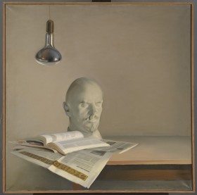 Obraz realistyczny w kwadracie. Na tle beżowej ściany fragment stołu. Na nim z lewej gazeta, otwarta książka i biała rzeźba głowy Lenina w ujęciu 3/4. Powyżej wisi srebrna lampka.