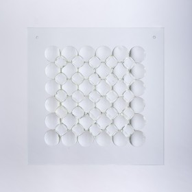 Szklana kompozycja przestrzenna w formacie kwadratu. Na przezroczystej szklanej tafli okrągłe soczewki w dwóch rozmiarach. Większe ułożone jedna przy drugiej w sześciu rzędach i sześciu kolumnach. Mniejsze wkomponowane są w luki pomiędzy większymi kołami, 